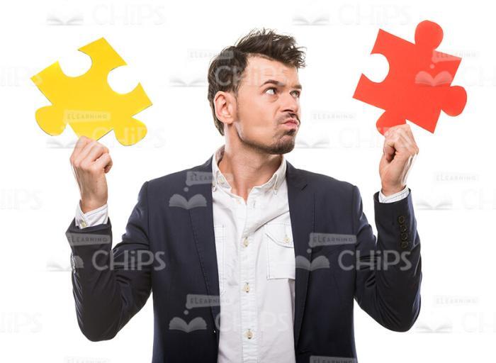 Nice Businessman Choosing Between Two Puzzle Pieces Stock Photo