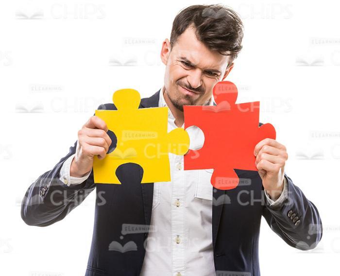 Stock Photo Of Businessman Tries To Connect Two Pieces Of Puzzle Stock Photo