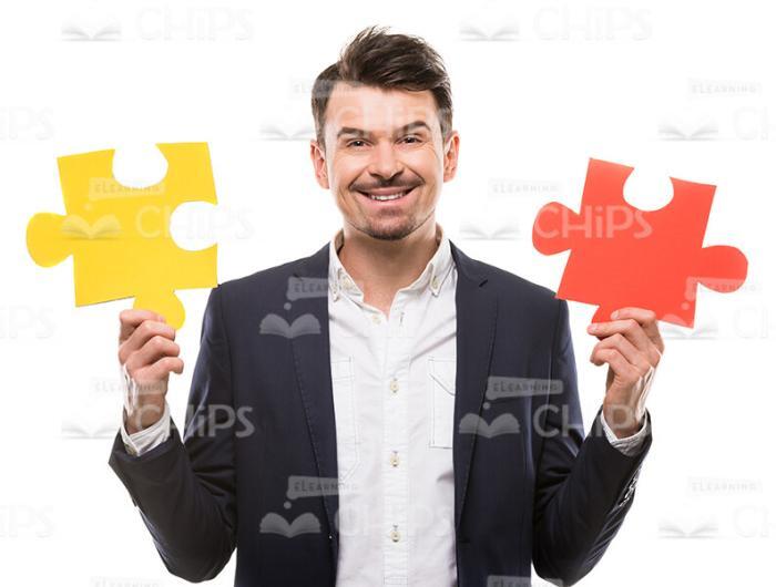 Cheerful Man Holding Puzzle Pieces Stock Photo