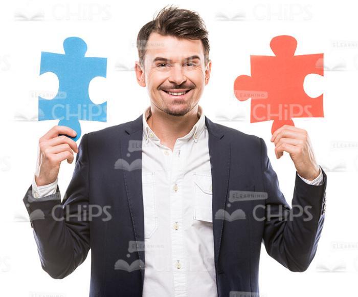 Male Character Holding Two Puzzle Pieces Stock Photo
