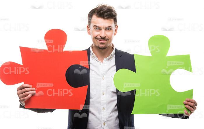 Handsome Man With Two Large Puzzle Pieces Stock Photo