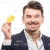 Happy Guy Dressed In Formal Suit Holding Puzzle Piece Stock Photo