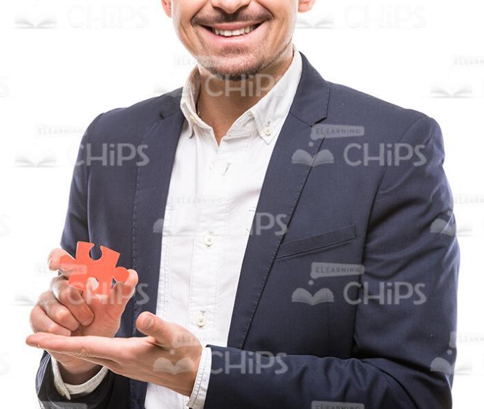 Smiling Guy Presenting Puzzle Piece Stock Photo
