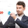 Attentive Man Going To Connect Puzzle Pieces Stock Photo