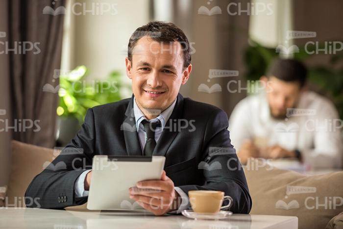 Smiling Businessman Using Tablet Stock Photo