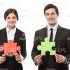 Businessman And Businesswoman With Puzzle Pieces Stock Photo On White Background