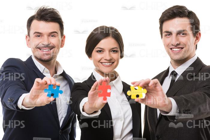 Isolated On White Smiling Business People Holding Puzzle Pieces Stock Photo