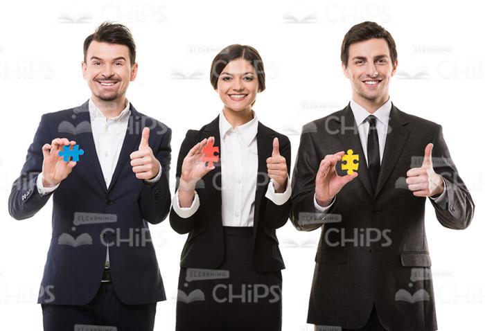 People With Little Puzzle Pieces Showing Their Thumbs Up Stock Photo