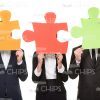 Business People Covering Heads With Large Puzzle Pieces Stock Photo