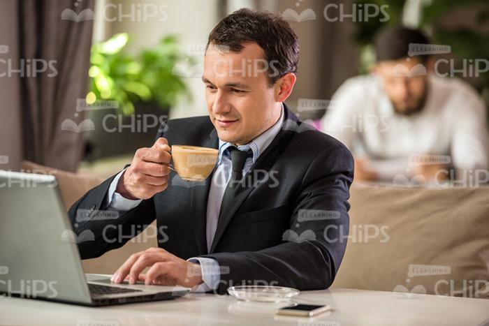 Businessman With Laptop Drinks Coffee Stock Photo