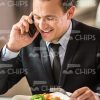 Business Man Laughing, Holding Fork And Talking On Phone Stock Photo