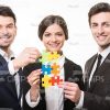 Smiling Business People Assembling Puzzles Stock Photo