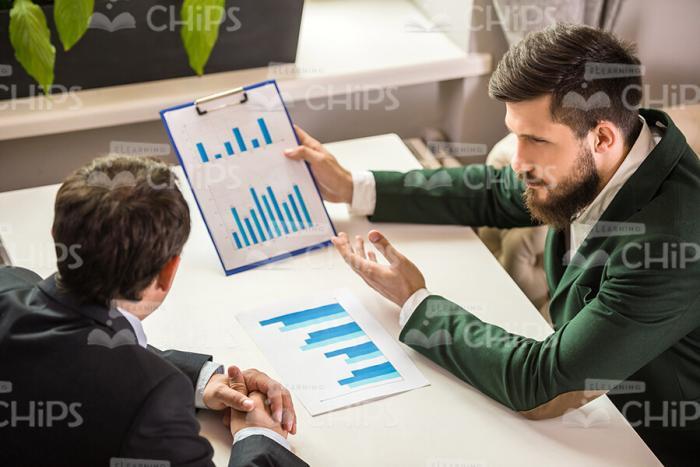 Two Businessmen Talking About Graphs Stock Photo