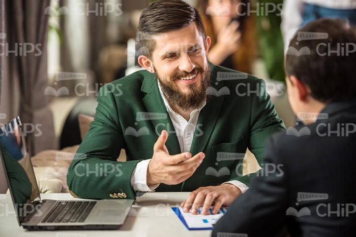 Smiling Businessman Talking To Companion Stock Photo
