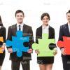 Business People Holding Large Puzzles Stock Photo