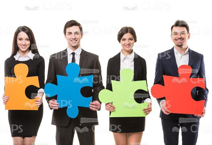 Business People Holding Large Puzzles Stock Photo