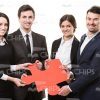 Four Business People Holding Piece Of Puzzle Stock Photo