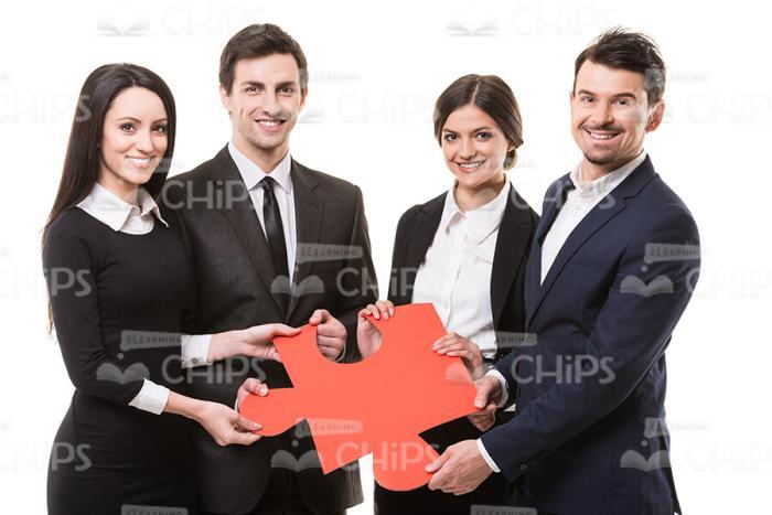 Four Business People Holding Piece Of Puzzle Stock Photo