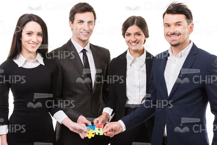 Four People And Small Pieces Of Puzzle Stock Photo