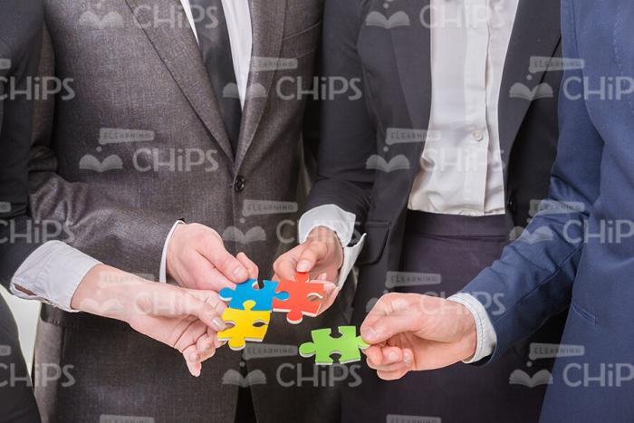 Small Pieces Of Puzzle In People Hands Stock Photo