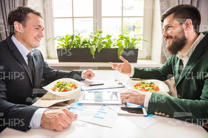 Two Businessmen Talking While Having Lunch Time Stock Photo