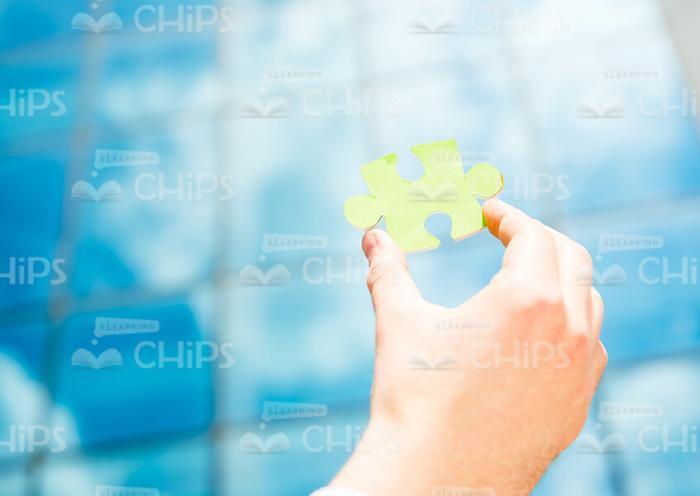 Hand Holding Small Piece Of Puzzle Stock Photo