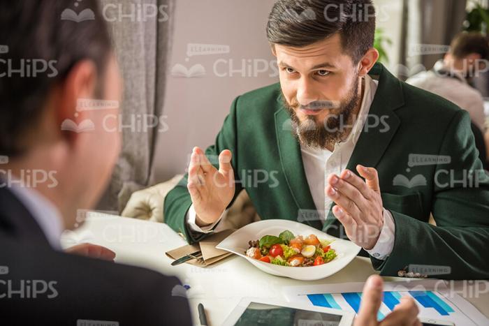 Partners Talking About Business During Lunch Stock Photo