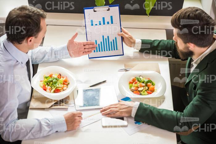 Businessmen Discussing During Lunch Stock Photo