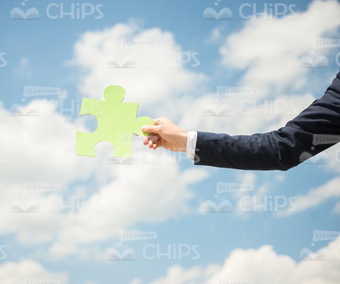 Hand Holding Jigsaw Puzzle On Blue Sky Background Stock Photo