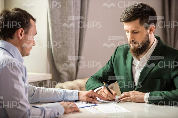 Two Businessmen Signing Contract Stock Photo
