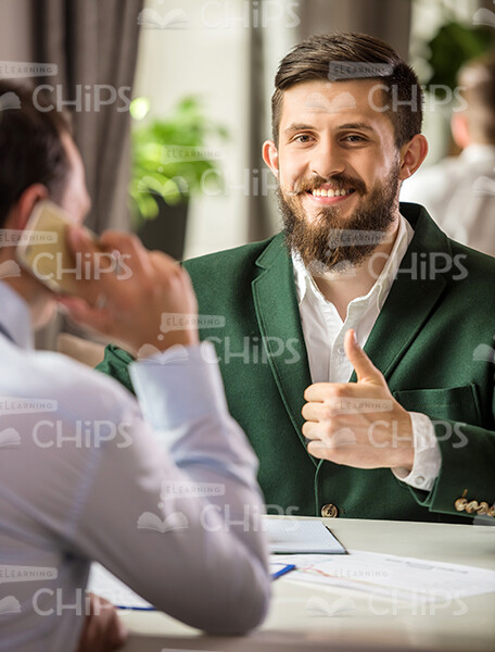 Businessman In Green Suit SHowing Thumb Up Stock Photo