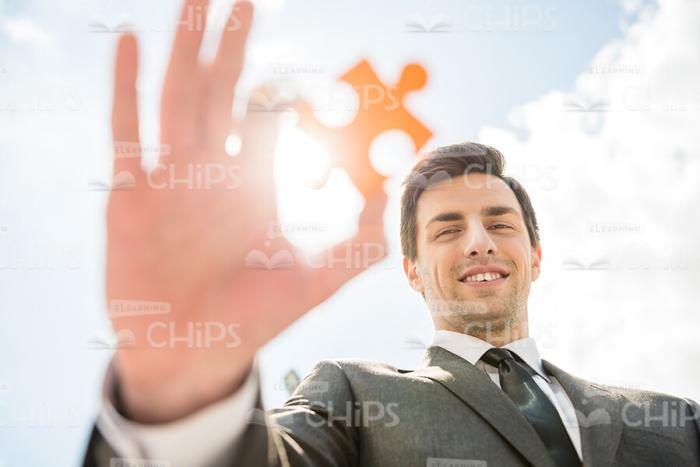 Young Man Holding Puzzle Piece Stock Photo