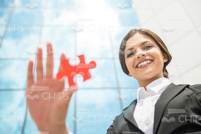 Young Businesswoman Holding Red Piece Of Puzzle Stock Photo