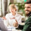Half-Turned Bearded Businessman Showing Thumb Up Gesture Stock Photo