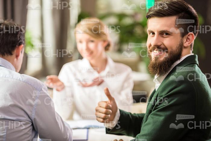 Half-Turned Bearded Businessman Showing Thumb Up Gesture Stock Photo