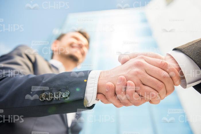 Smiling Businessman Greeting His Partner Stock Photo