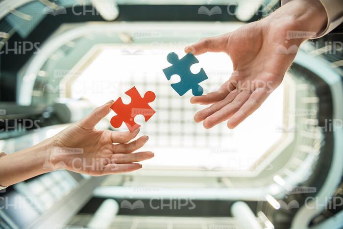 Two Small Puzzle Pieces In People Hands Stock Photo