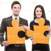 Man And Woman Holding Big Pieces Of Puzzle Stock Photo