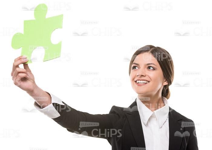 Green Puzzle Piece In Woman's Outstretched Hand Stock Photo