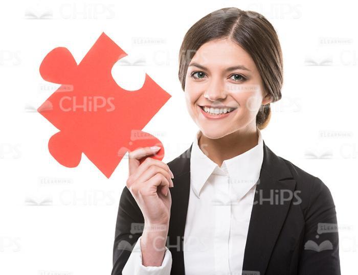 Happy Businesswoman Holding Jigsaw Puzzle Stock Photo