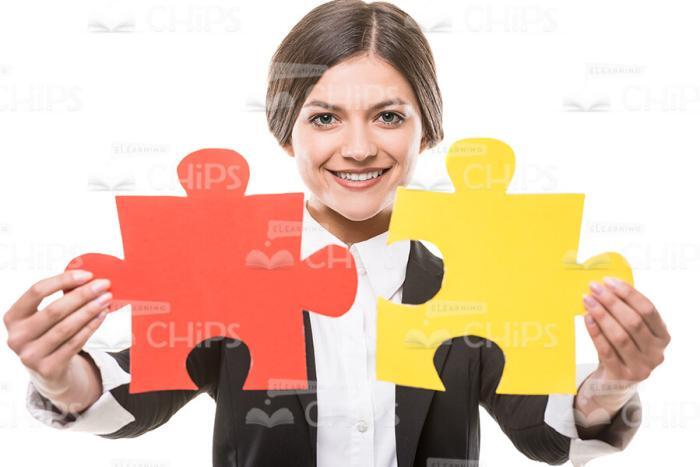 Successful Businesswoman Holds Two Pieces Of Puzzle Stock Photo