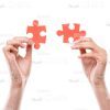 Hands Holding Small Red Jigsaw Pieces Stock Photo