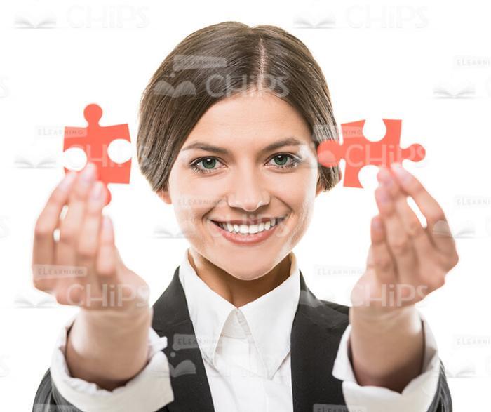 Smiling Businesslady Presenting Small Jigsaw Puzzles Stock Photo