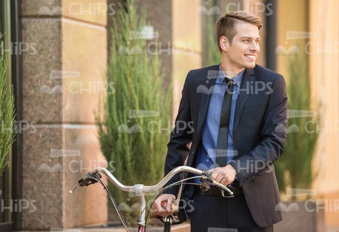 Confident Businessman Walking With Bicycle Stock Photo