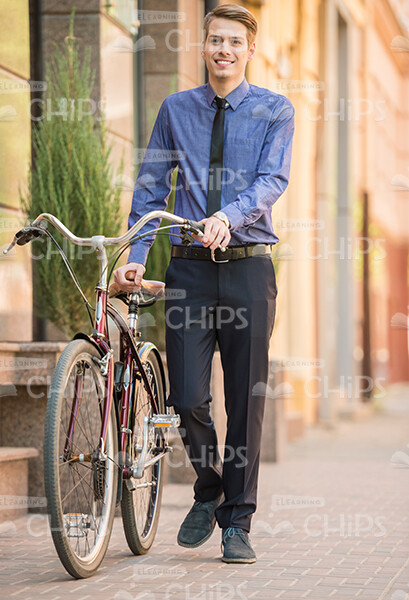 Smiling Man Walking On The Street With His Bike Stock Photo