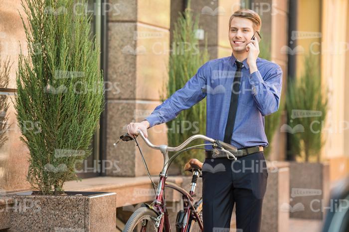 Happy Man With Bike Talking On Mobile Phone Stock Photo