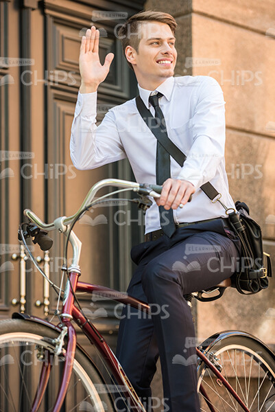 Man Riding Bike While Waving His Right Hand Stock Photo