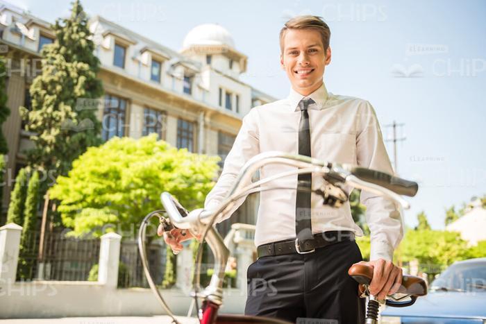 Nice Man With Bicycle Walking Through The City Stock Photo