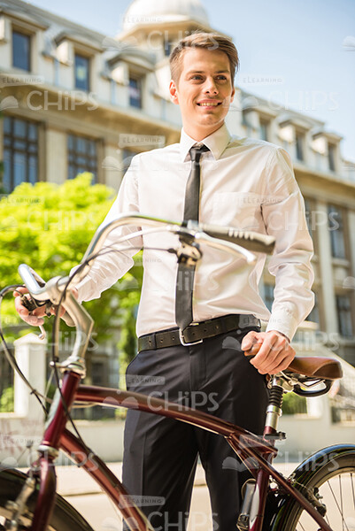 Handsome Businessman Standing Next To His Bicycle Stock Photo
