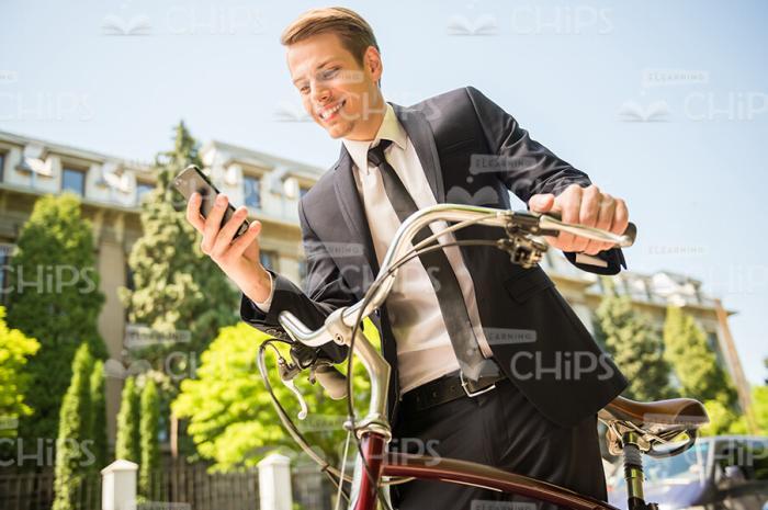 Nice Businessman Using Phone And Going To Ride On Bicycle Stock Photo